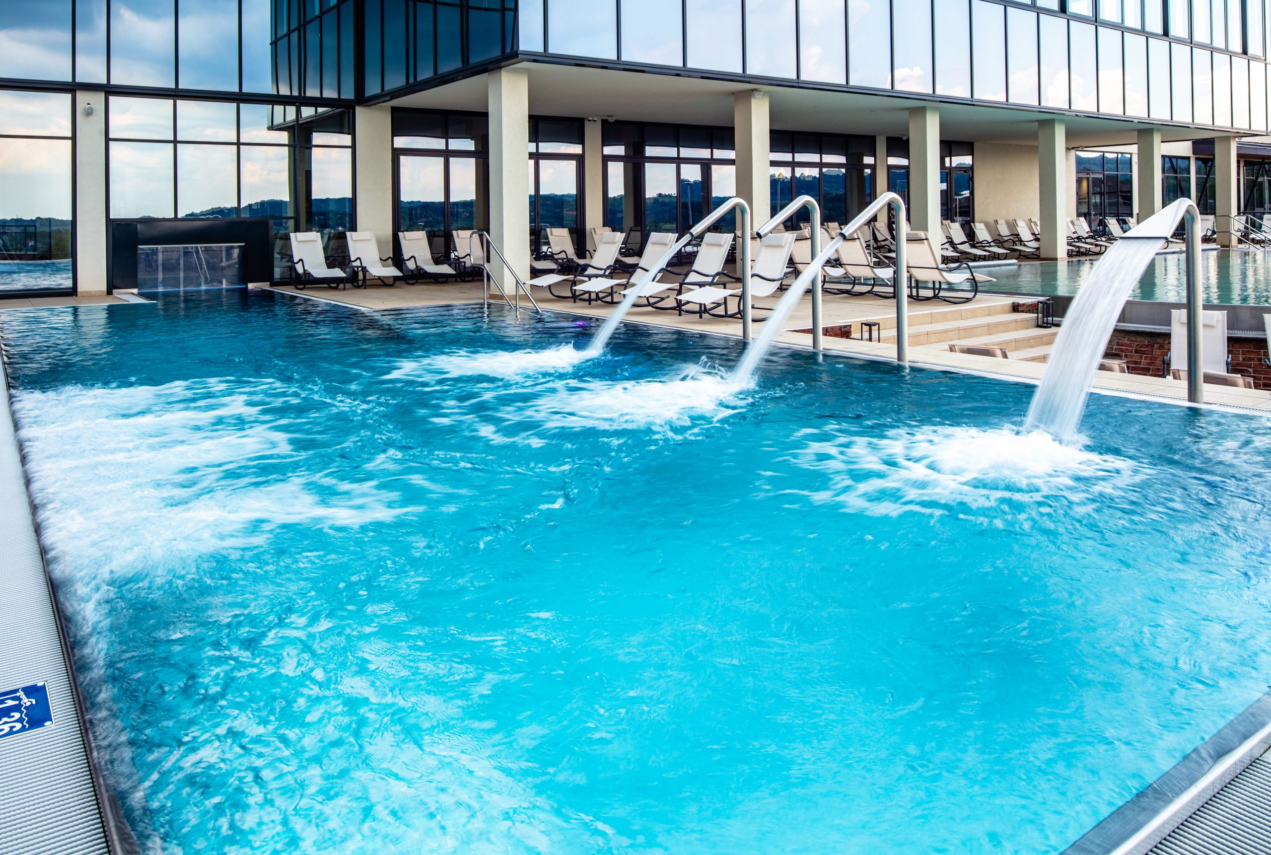 Empty swimming pool with hydrotherapy showers at health spa. Copy space.